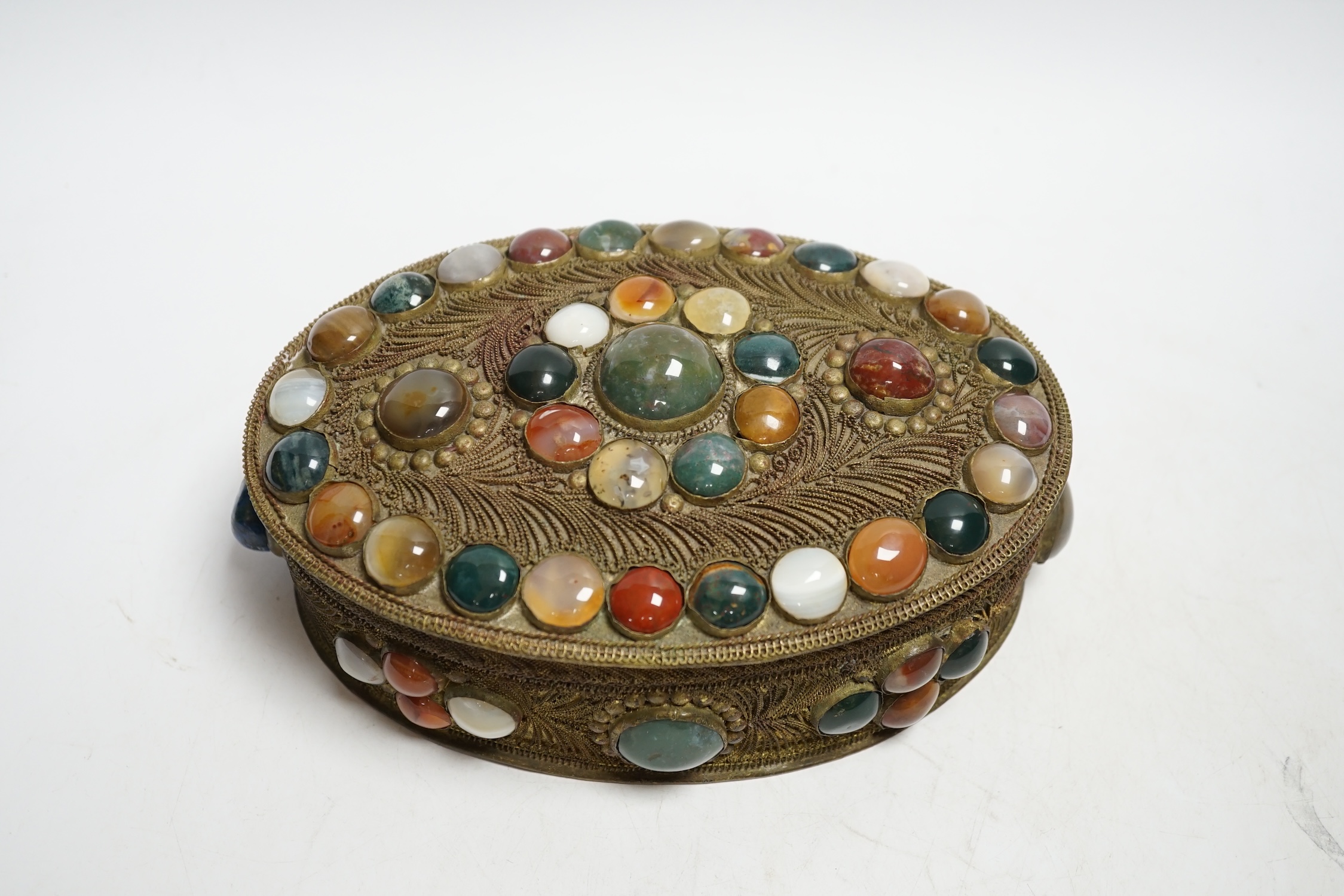 A brass filigree work and agate cabochon mounted oval box, 19cm wide